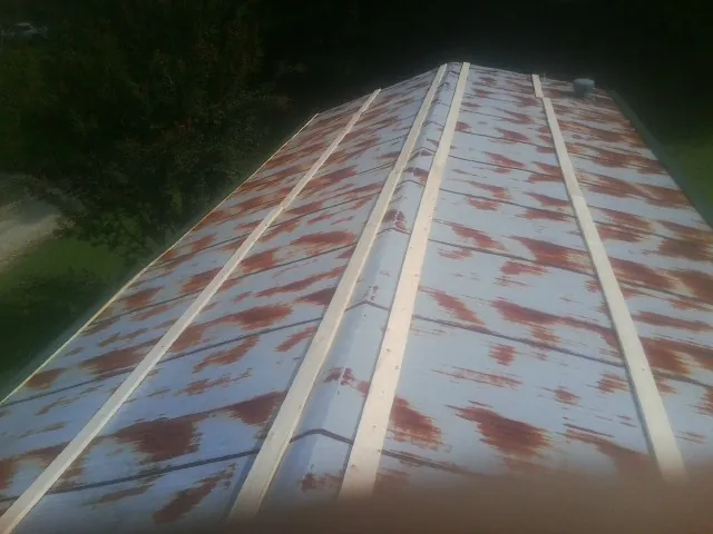Rusted metal roof panels with new wood purlins before replacement — Storm Damage Roof Repair in Etowah by Roofing Brothers